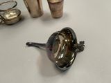 a spoon with a spoon rest on a table next to cups