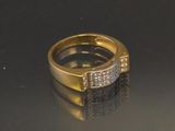 une image d'une bague en or et en diamant sur une surface noire