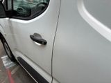 a white van parked in a parking lot next to a parking meter