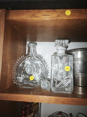 two bottles of liquor on a shelf in a cabinet