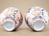 pair of asian vases with floral designs on them sitting on a table