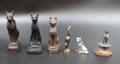 Plusieurs figurines représentant des chats et des chiens sont alignées sur une table