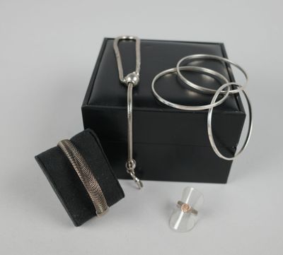 une boîte noire contenant un collier argenté et un portefeuille noir