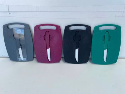 quatre sacs de voyage en plastique de couleurs différentes alignés contre un mur blanc