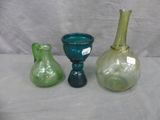 three different colored glass vases sitting on a table
