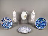 cinq types différents d'assiettes décoratives et de vases exposés