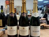 trois bouteilles de champagne sont alignées sur une table