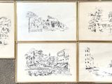 four framed drawings of buildings on a wall in a living room