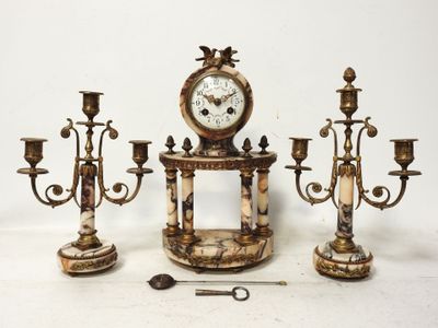 trois bougies et une horloge posées sur une table