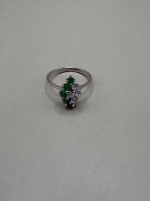 a close up of a silver ring with a green and white stone
