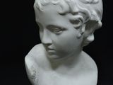 un buste en marbre blanc représentant un jeune garçon aux cheveux bouclés