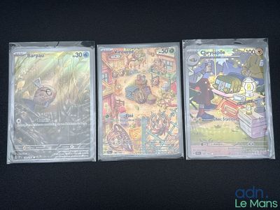 trois cartes à collectionner Pokémon posées sur une table noire