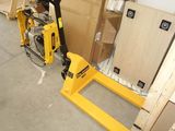 a fork lifter sitting next to a pallet in a warehouse