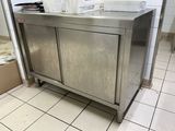 a stainless steel cabinet in the middle of a tiled floor