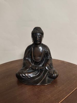 a statue of a buddha sitting on top of a wooden table