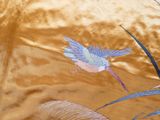 a bird that is flying in the air near some plants