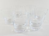 four glasses sitting on a table with a white background