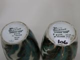 two vases that have been decorated with leaves on them