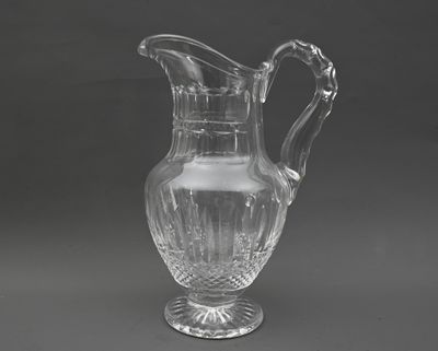 un pichet en verre transparent posé sur une table dont le plateau est gris