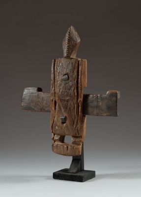a wooden sculpture of a person holding a cross on top of a table