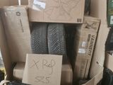un tas de pneus dans un carton sur lequel est accrochée une pancarte