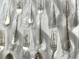a lot of silver spoons and forks on the table