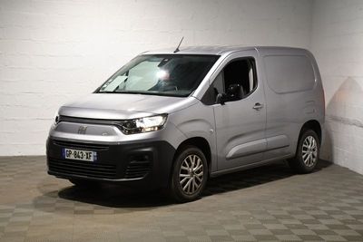 une camionnette Citroën garée dans un garage au sol carrelé