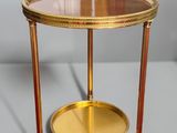 an image of a gold and glass side table on a grey surface