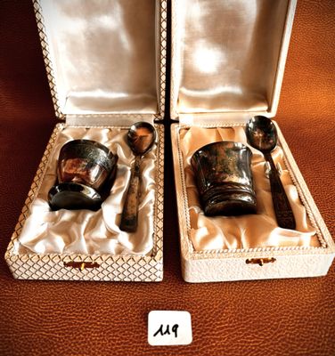 two silver spoons and a glass in a box