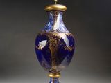 un vase bleu et or posé sur une table