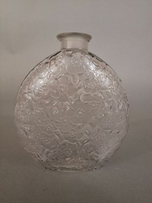 a clear glass bottle with a silver lid on a table