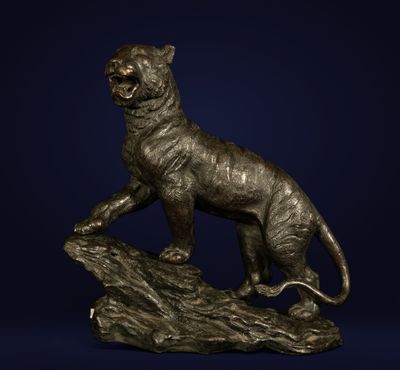 une statue en bronze représentant un tigre perché sur un rocher