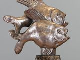 a statue of two fish on a marble base