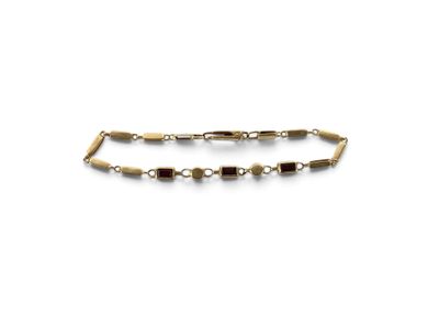 un gros plan d'un bracelet en or orné de perles sur fond blanc
