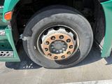 a green bus that has a flat tire on it