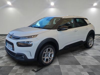 a white citrole is parked in a room with a checkered floor