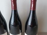 three bottles of wine sitting on a table next to each other