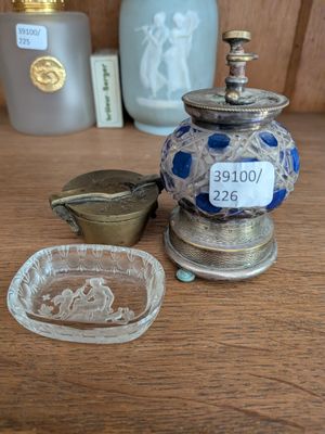 un vase bleu et blanc posé sur une table, à côté d'une assiette en verre