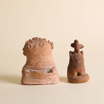 deux figurines en argile posées l'une à côté de l'autre sur une table