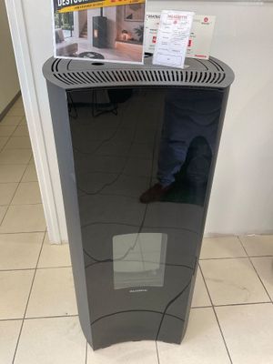 un purificateur d'air noir posé au sol dans une pièce