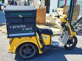 a yellow scooter with a box on the back of it