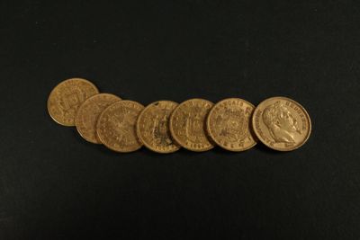 un gros plan sur un tas de pièces d'or posées sur une surface noire