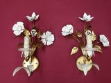 two wall sconces with flowers on each of them
