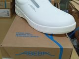 une chaussure blanche posée sur une boîte