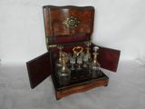 a small wooden box with a set of glass bottles in it