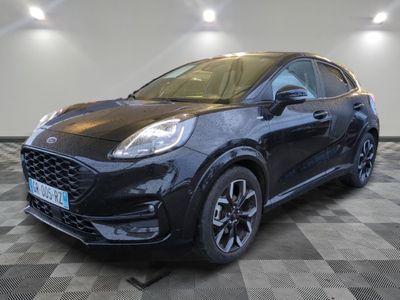 une Ford Fiesta noire garée sur un sol à damier dans un garage