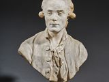 un buste en marbre blanc représentant un homme en costume-cravate