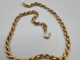 a gold rope necklace with a clasp on a white background