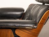 an image of a black leather lounge chair and ottoman in a room