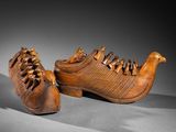 pair of carved shoes with a bird on the sole